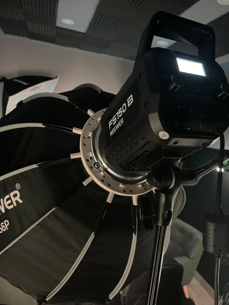 Foco LED de estudio encendido con su softbox parabólico montado, bajo el techo acústico